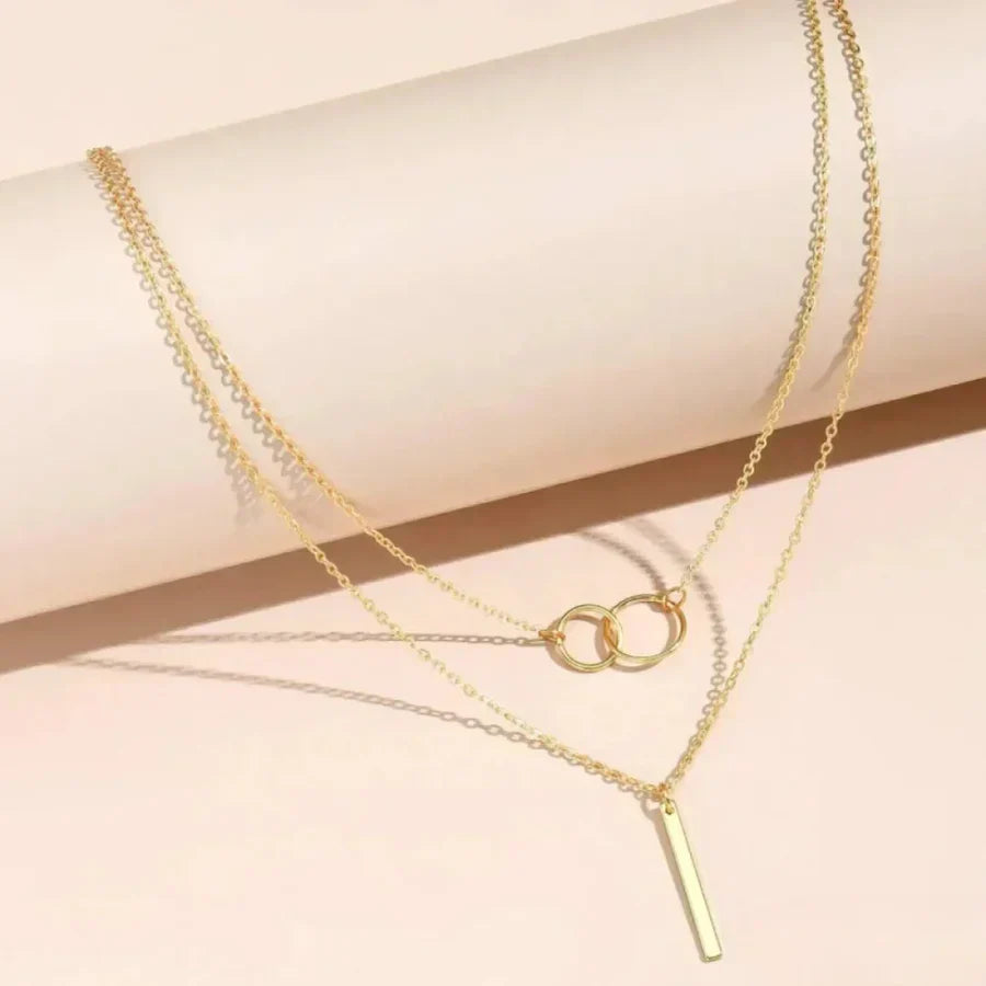Collar de varias hileras con anillos y elegante colgante de barra
