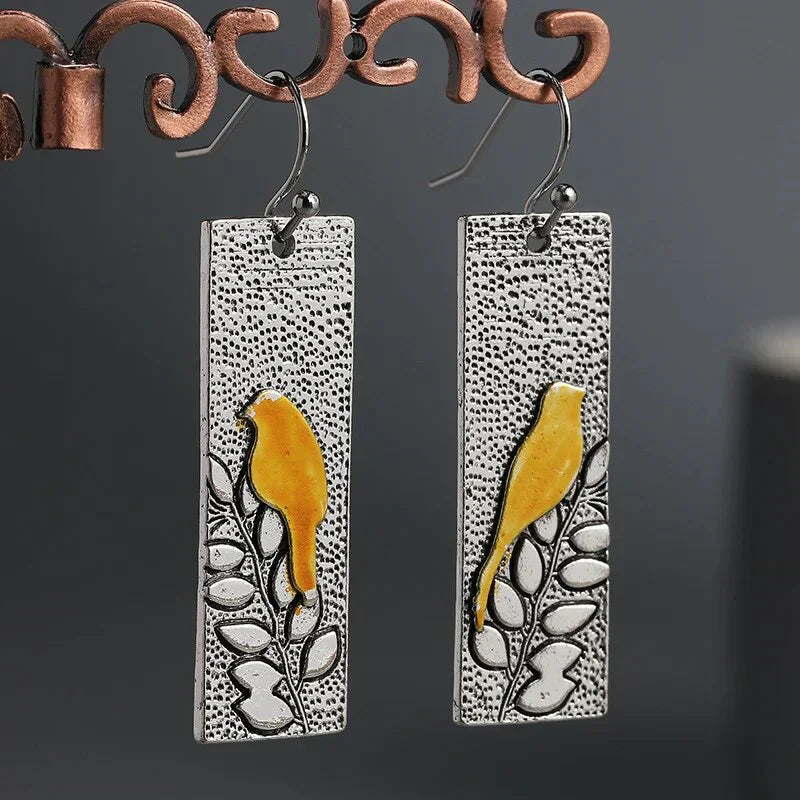Pendientes vintage con diseño de pájaro amarillo y zarcillo floral