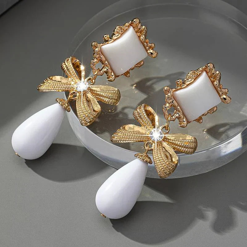 Elegantes pendientes vintage con piedra blanca y colgante de lazo
