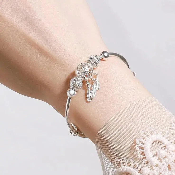 Brazalete atrapasueños de filigrana con colgantes de plumas y bolas ornamentales