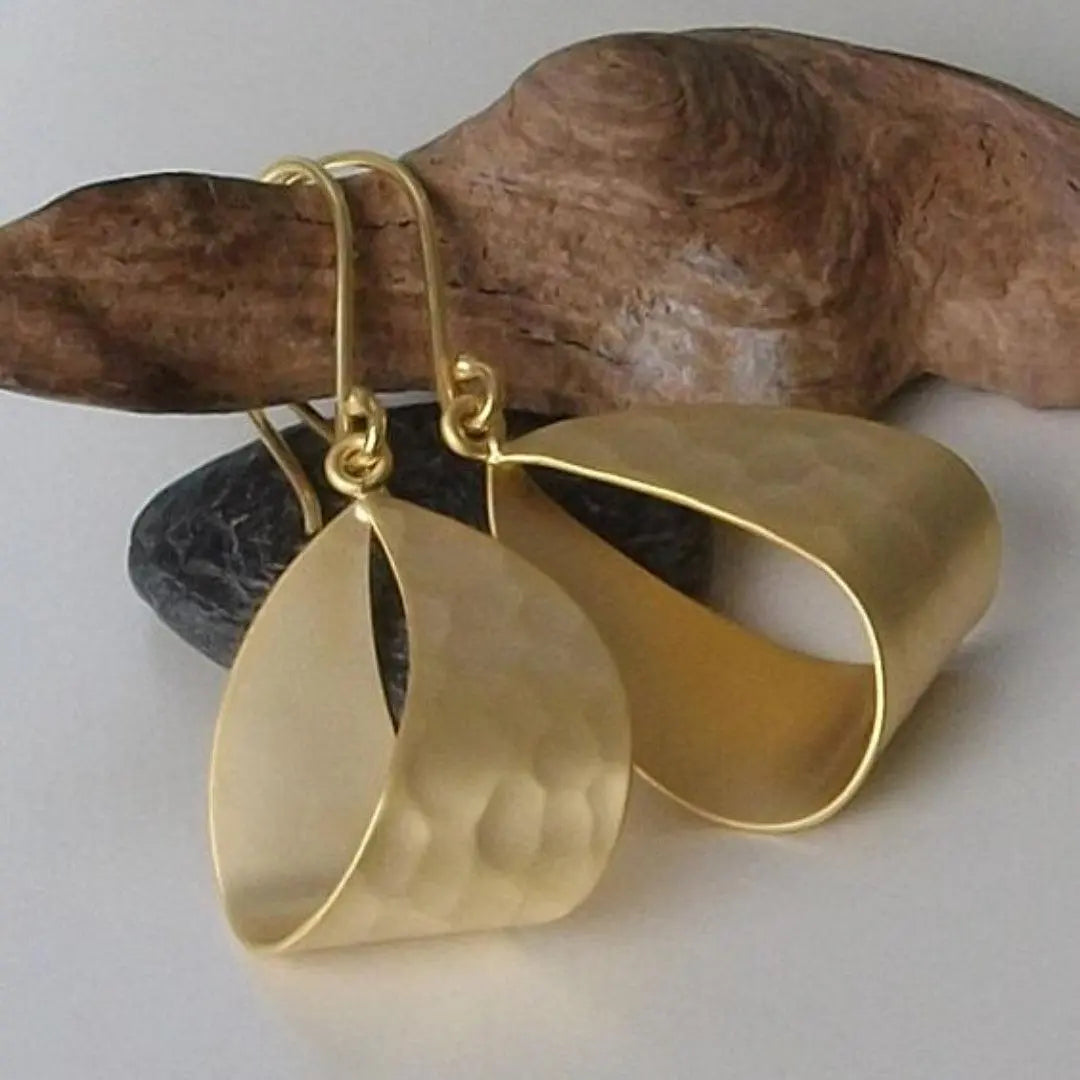 Pendientes elegantes bañados en oro con una moderna textura martillada