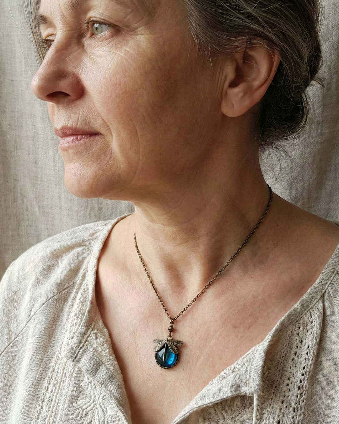 Collar de libélula de bronce con piedra de cristal facetada de color azul intenso