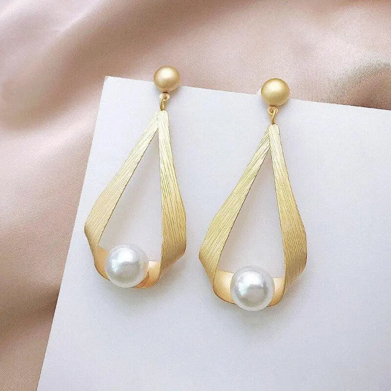 Elegantes pendientes de perlas en tono oro mate con detalles flotantes