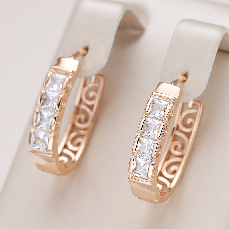 Pendientes de aro elegantes en oro rosa con circonitas brillantes y diseño artístico