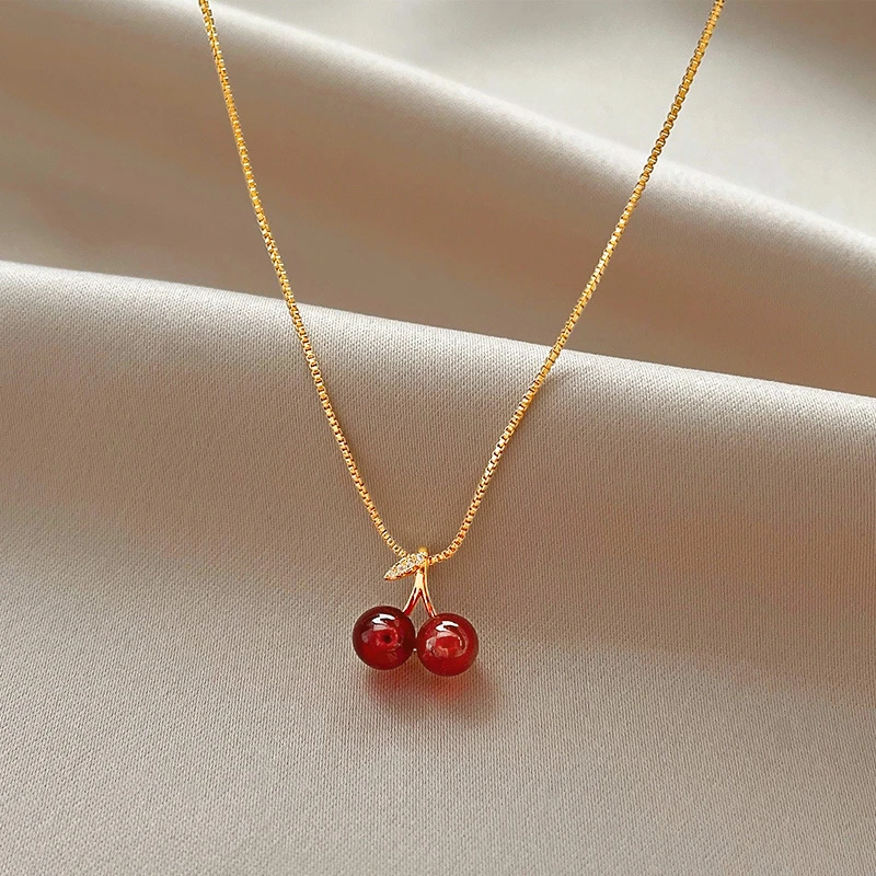 Elegante collar de cerezas con hojas brillantes y colgantes rojos