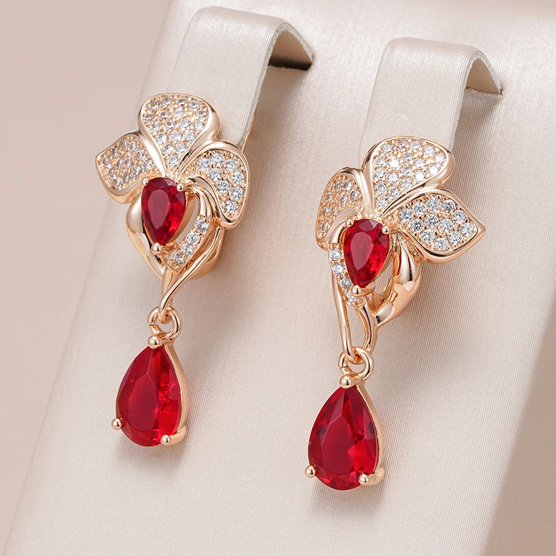 Pendientes elegantes de flores con circonitas y piedras rojas en forma de lágrima