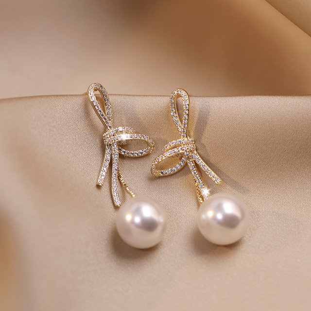 Pendientes de lazo elegantes con circonitas brillantes y perlas