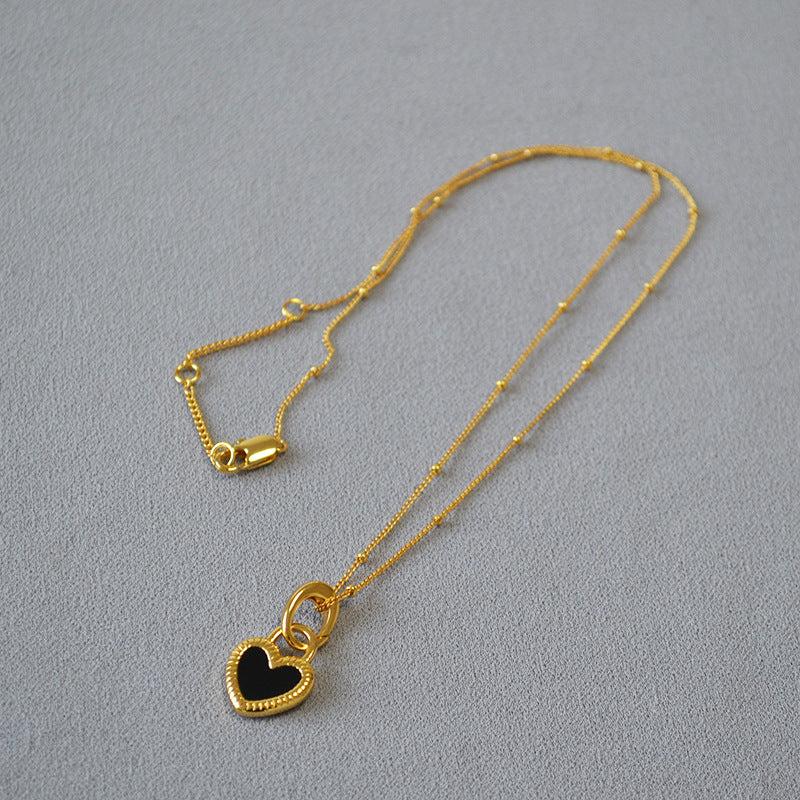 Collar de oro con colgante de corazón blanco y negro