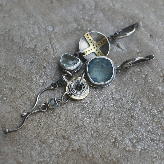 Pendientes asimétricos con piedras azules y elementos en forma de cruz