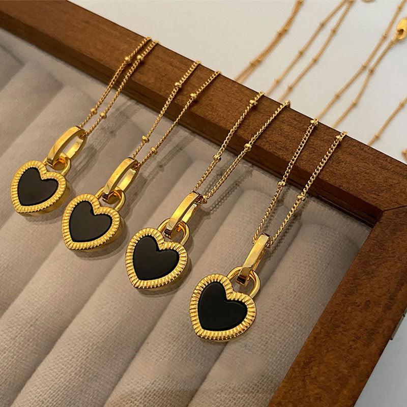 Collar de oro con colgante de corazón blanco y negro