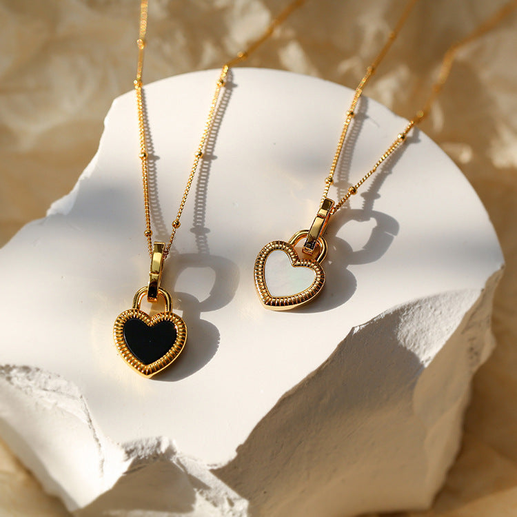 Collar de corazón blanco y negro con cadena de eslabones finos y detalles de perlas