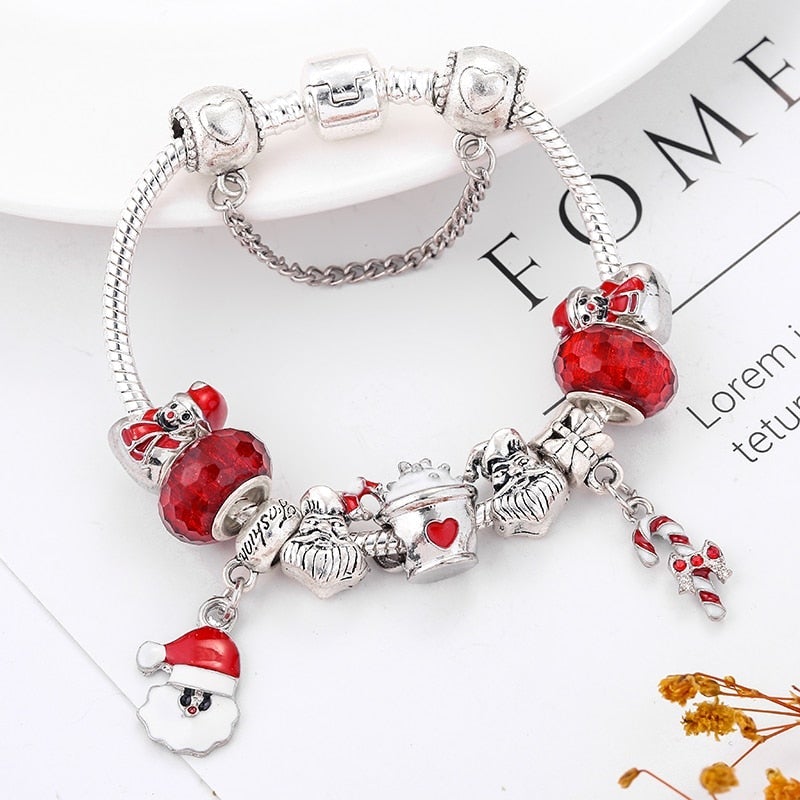 Pulsera navideña festiva con cristales rojos y figuras de Papá Noel