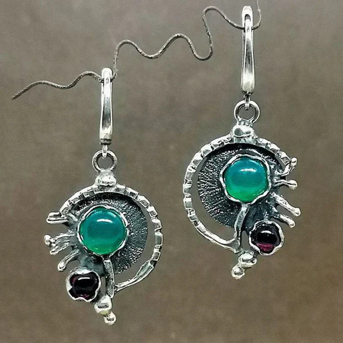 Pendientes con piedras ovaladas de turquesa y detalles oscuros