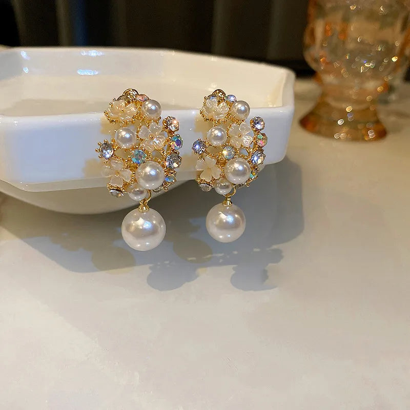 Pendientes de flores elegantes con pedrería brillante y perlas lujosas
