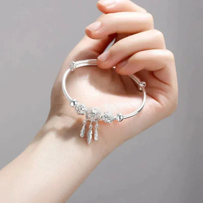 Brazalete atrapasueños de filigrana con colgantes de plumas y bolas ornamentales