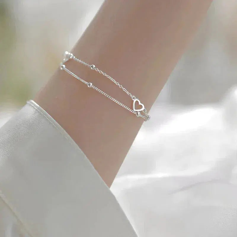 Elegante pulsera de doble cadena con corazones y cuentas finas