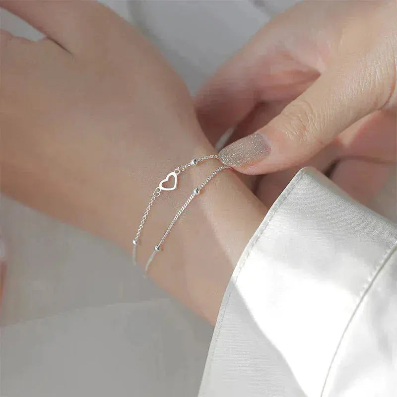 Elegante pulsera de doble cadena con corazones y cuentas finas