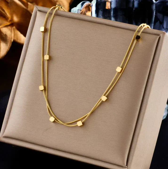 Collar moderno de dos hileras con elementos de cubos geométricos