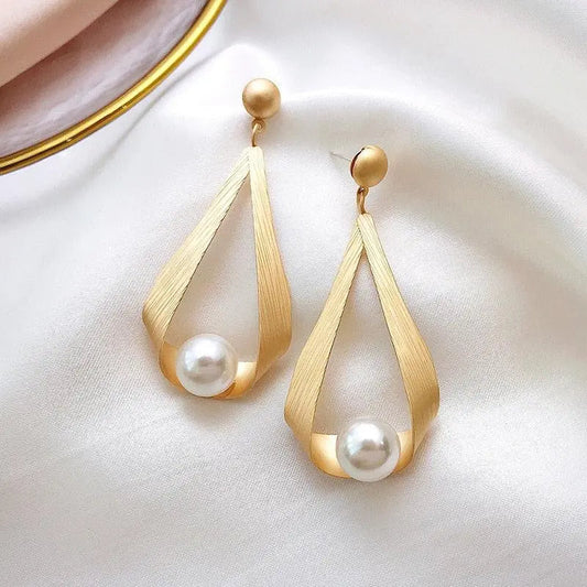 Elegantes pendientes de perlas en tono oro mate con detalles flotantes
