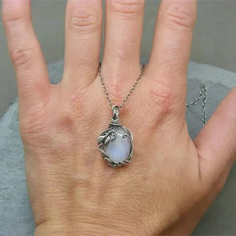 Collar colgante de piedra lunar natural envuelto a mano con hojas artísticas