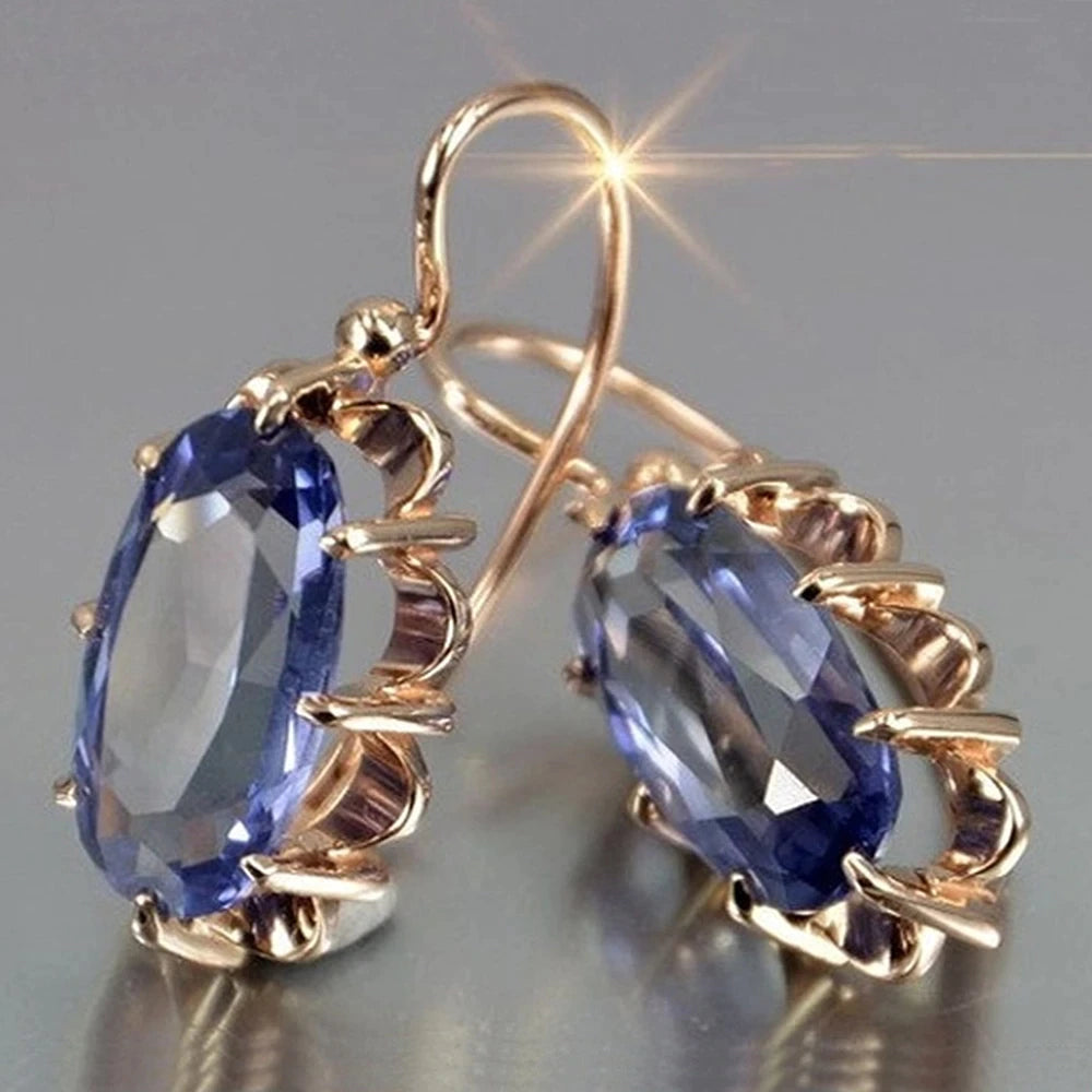 Elegantes pendientes de gancho con gema azul ovalada y facetada