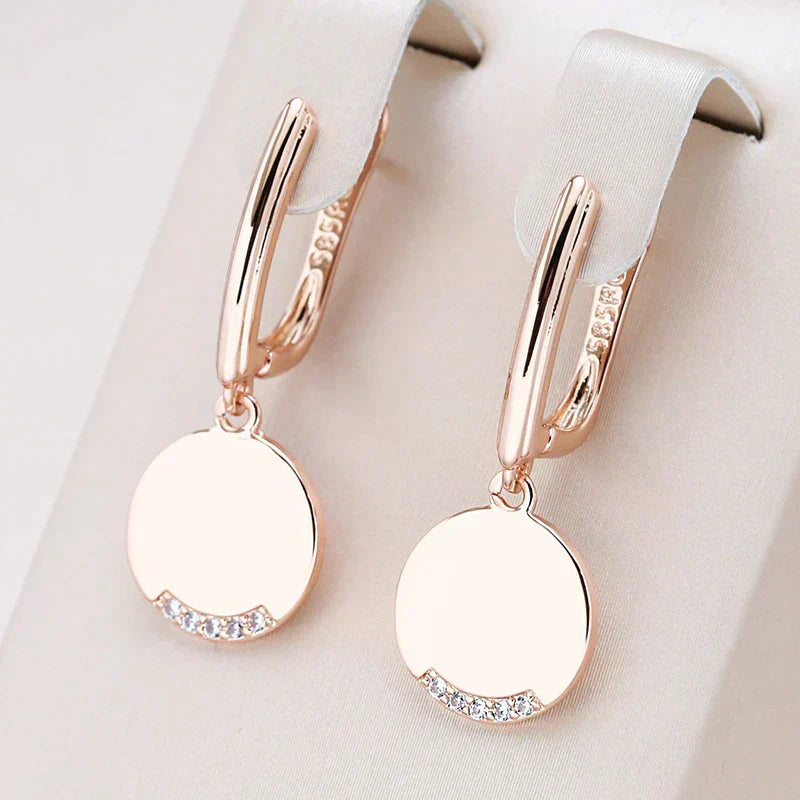 Elegantes criollas bañadas en oro rosa con circonitas y colgantes redondos