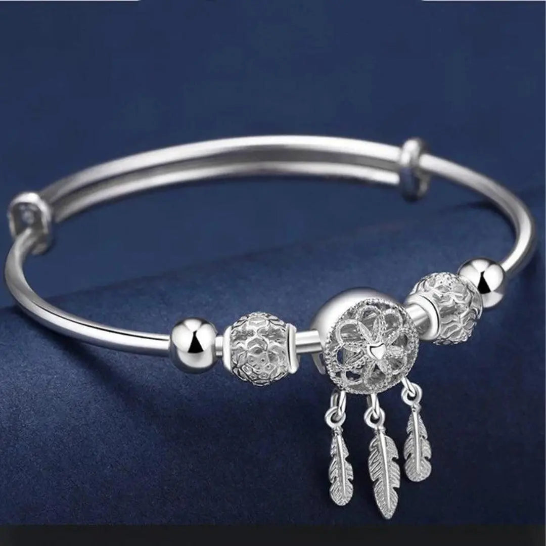Brazalete atrapasueños de filigrana con colgantes de plumas y bolas ornamentales