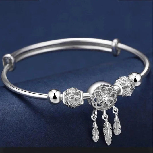 Brazalete atrapasueños de filigrana con colgantes de plumas y bolas ornamentales