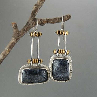 Pendientes rústicos con piedra gris oscuro y detalles dorados