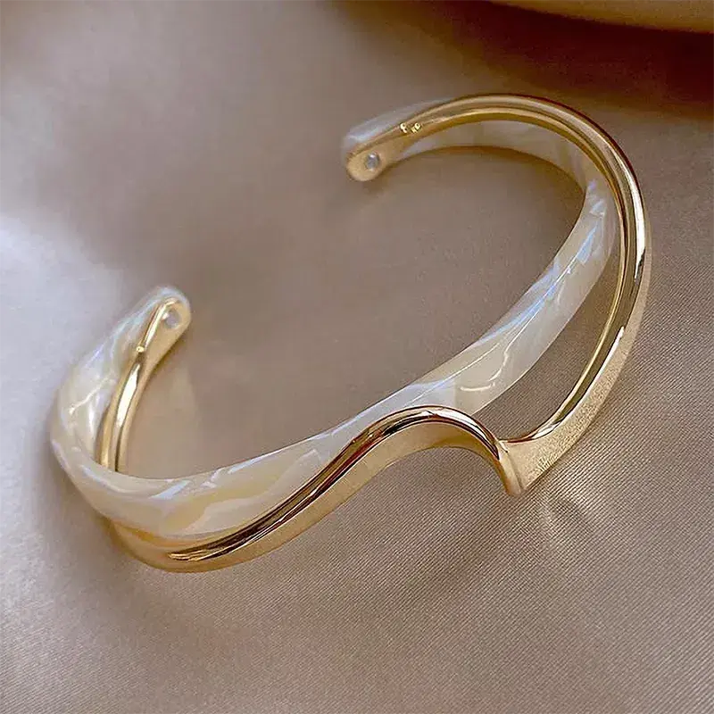 Pulsera moderna con diseño ondas en aspecto de nácar y metal
