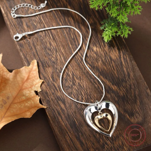 Collar de corazón bicolor con un delicado colgante de corazón entrelazado