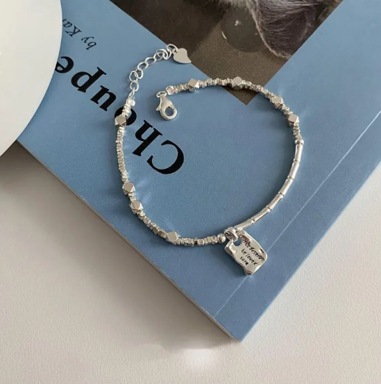 Pulsera glamorosa con elementos de geometría, detalles de corazón y perlas