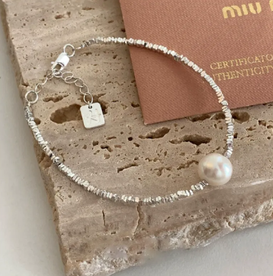 Pulsera glamorosa con elementos de geometría, detalles de corazón y perlas