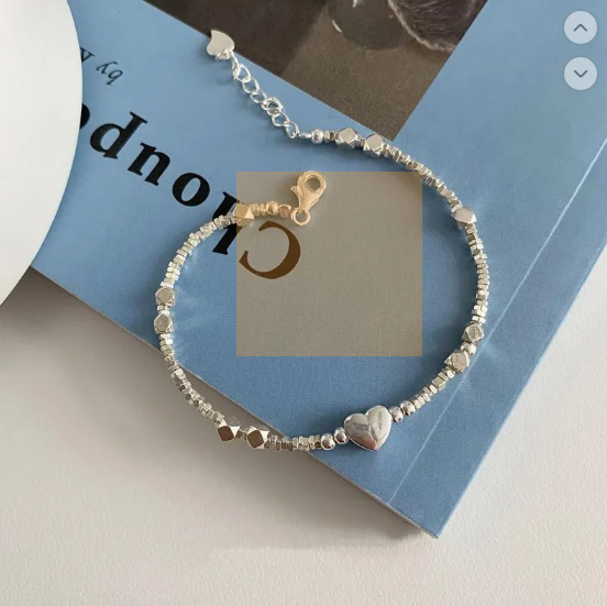 Pulsera glamorosa con elementos de geometría, detalles de corazón y perlas
