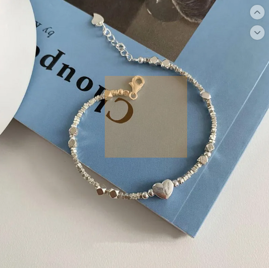 Pulsera glamorosa con elementos de geometría, detalles de corazón y perlas