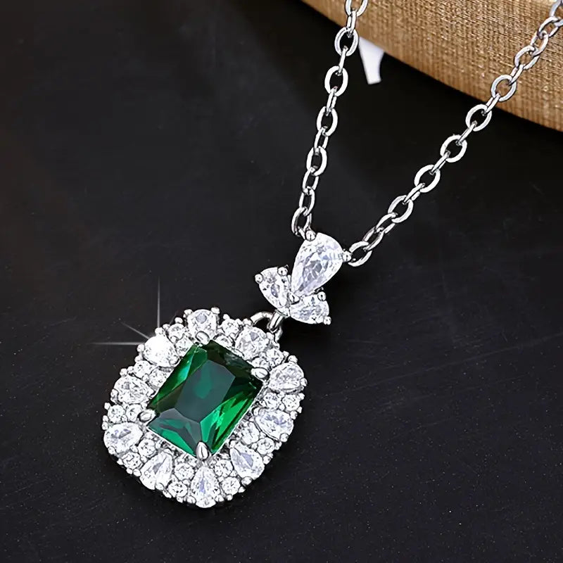 Elegante colgante de esmeralda con halo de circonitas sobre una delicada cadena