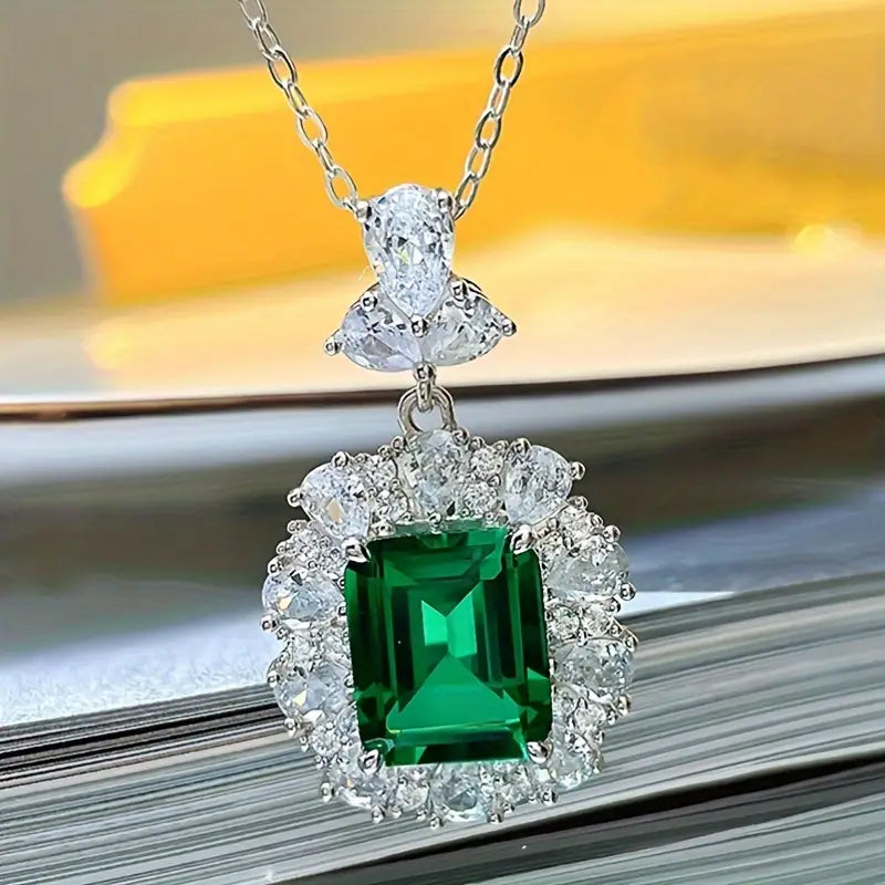 Elegante colgante de esmeralda con halo de circonitas sobre una delicada cadena