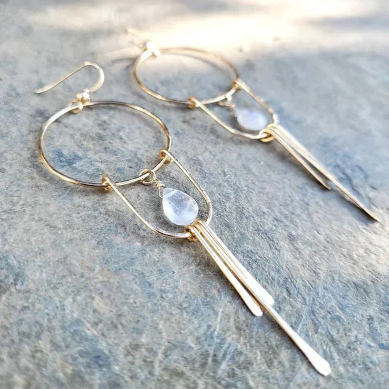 Pendientes elegantes con piedra preciosa blanca y gotas oscilantes