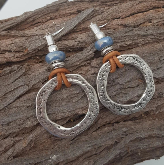 Pendientes hechos a mano con cuentas de cristal azul y detalles en cuero
