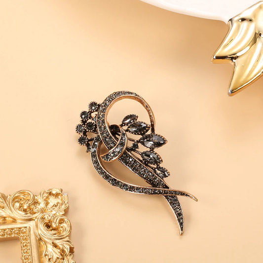 Elegante broche vintage con pedrería y motivo de hojas