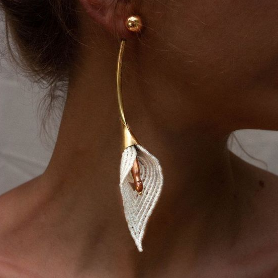 Pendientes de flores elegantes con delicado follaje blanco y tallo