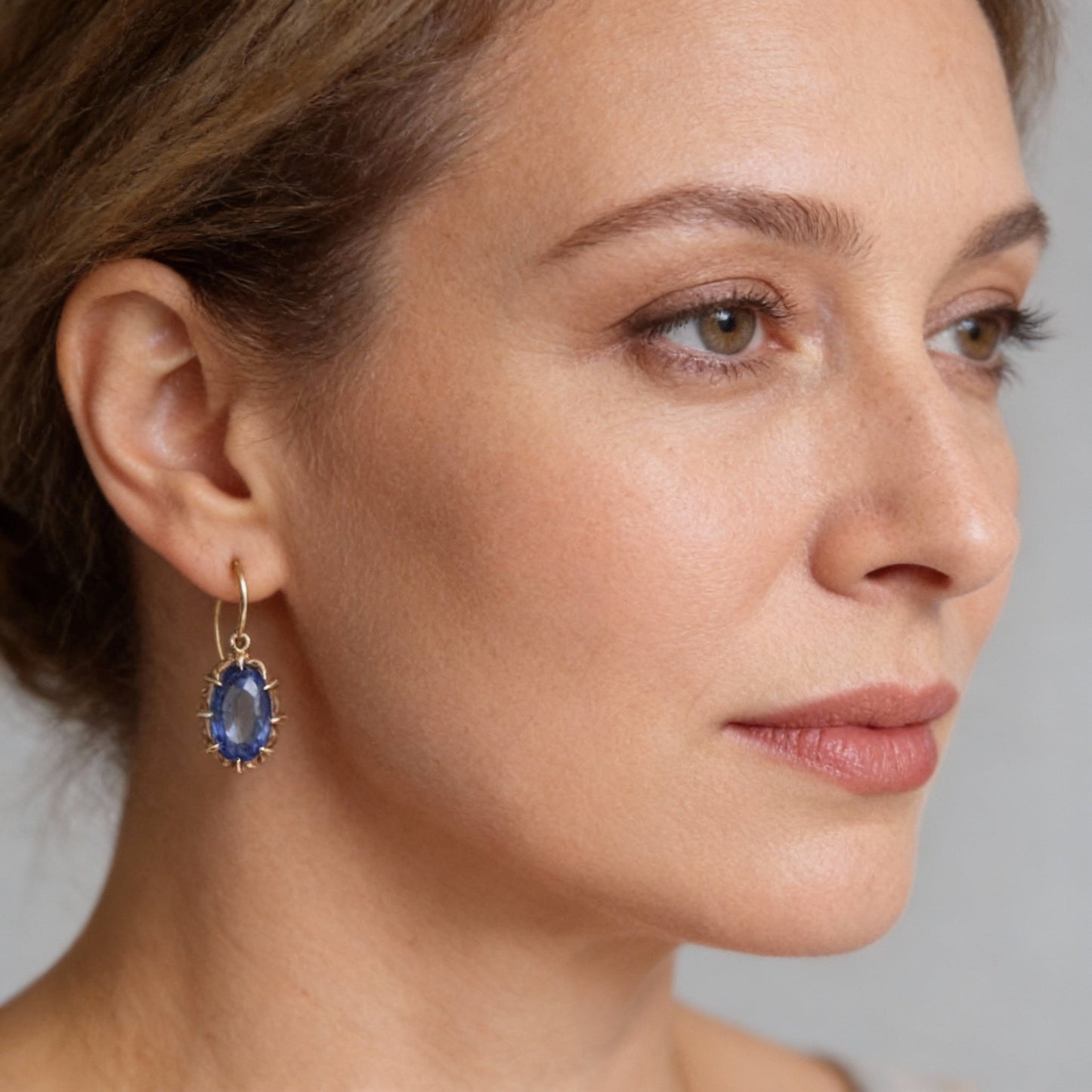 Elegantes pendientes de gancho con gema azul ovalada y facetada