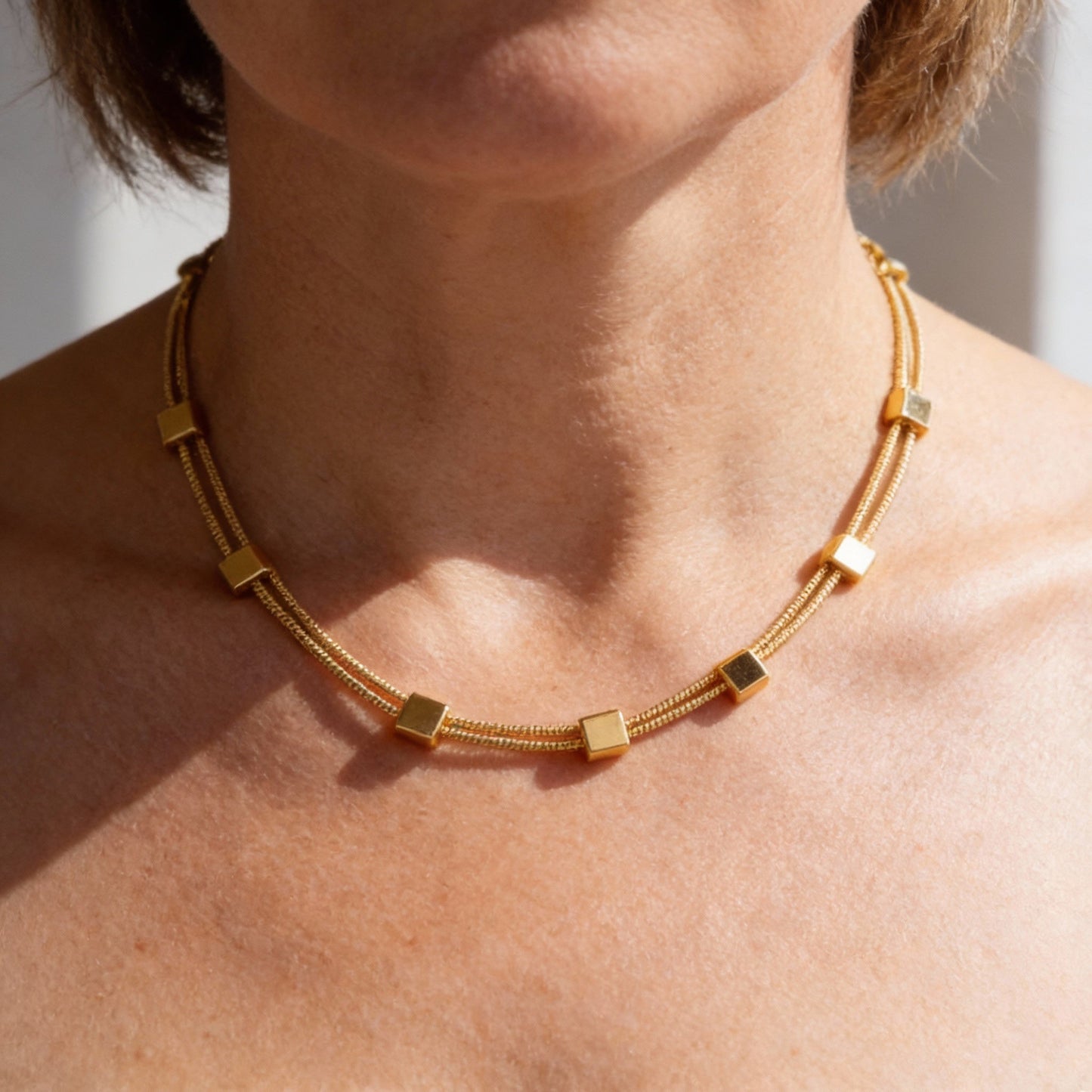 Collar moderno de dos hileras con elementos de cubos geométricos