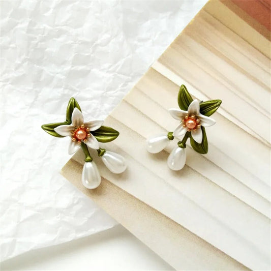 Pendientes elegantes con flores de perlas y hojas verdes
