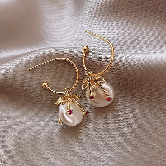 Elegantes pendientes de perlas con delicadas hojas y detalles en rojo