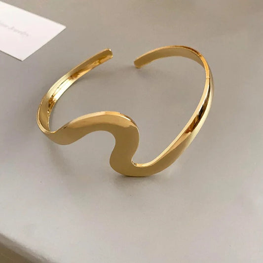 Elegante pulsera abierta con diseño ondulado y brillante